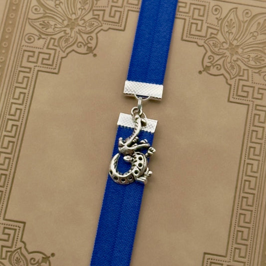 A silver crocodile charm on a elastic Bookband