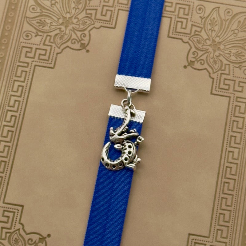 A silver crocodile charm on a elastic Bookband