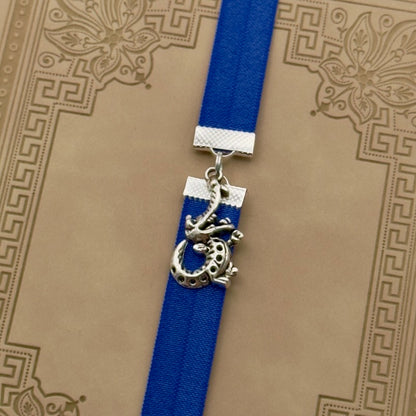 A silver crocodile charm on a elastic Bookband