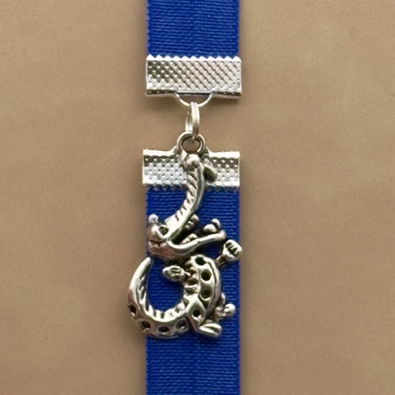 A silver crocodile charm on a elastic Bookband