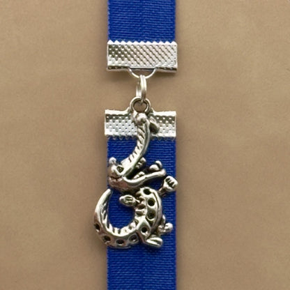 A silver crocodile charm on a elastic Bookband