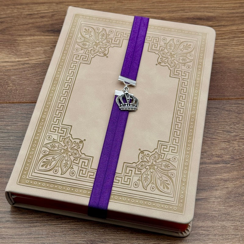 A silver royal crown charm on an elastic Bookband