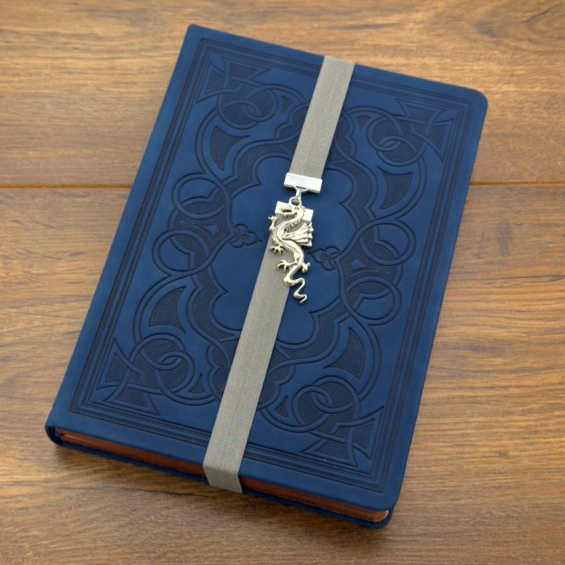 A silver dragon charm on a elastic Bookband
