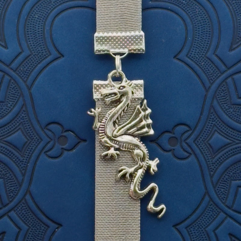 A silver dragon charm on a elastic Bookband
