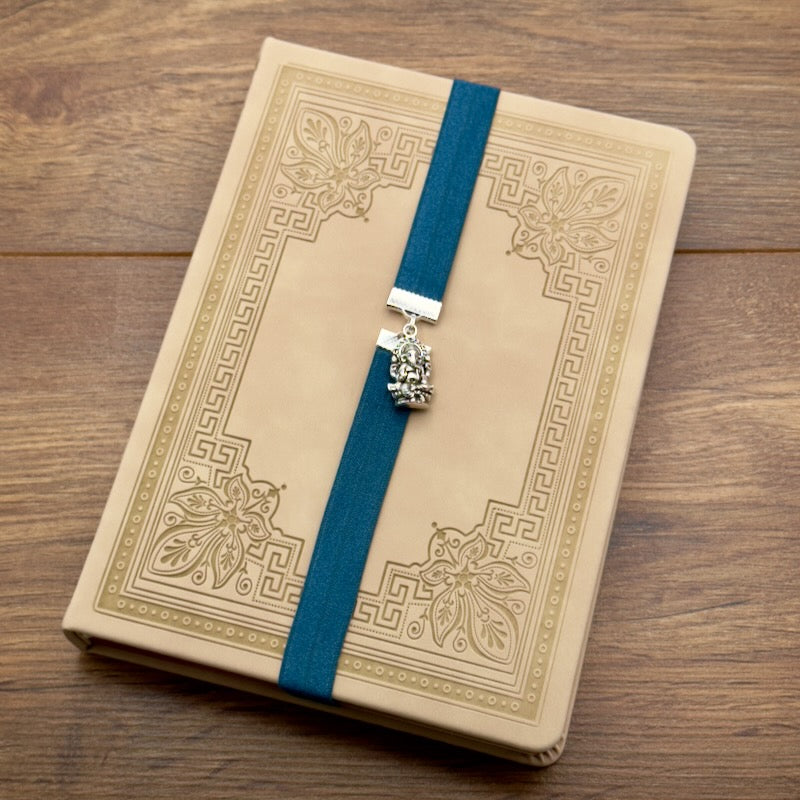 A silver Ganesha charm on a elastic Bookband
