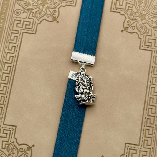 A silver Ganesha charm on a elastic Bookband