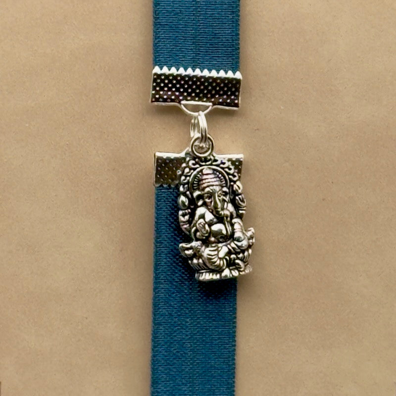 A silver Ganesha charm on a elastic Bookband