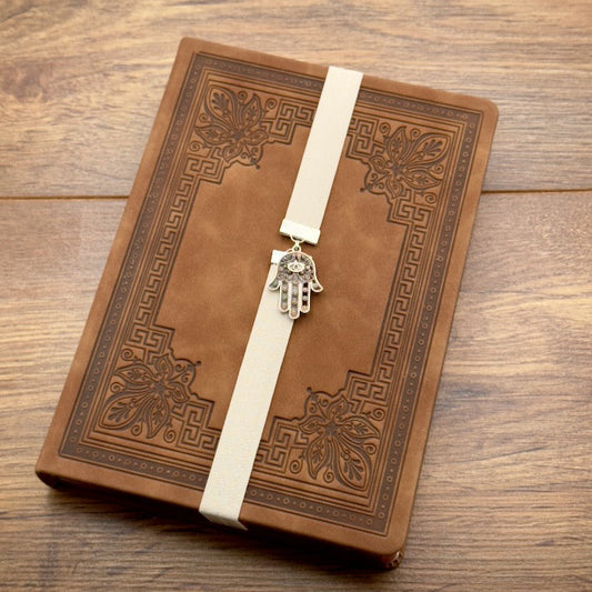 A silver Hamsa charm on a elastic Bookband