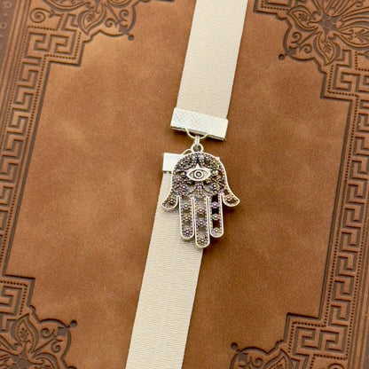 A silver Hamsa charm on a elastic Bookband