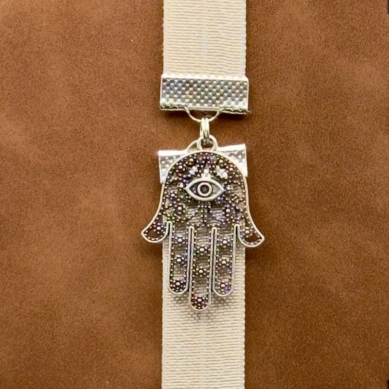 A silver Hamsa charm on a elastic Bookband
