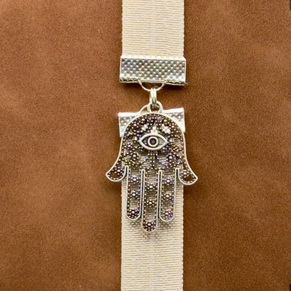 A silver Hamsa charm on a elastic Bookband