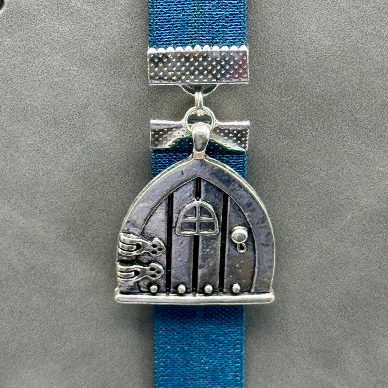 A silver arched door charm on an elastic Bookband
