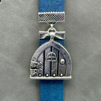 A silver arched door charm on an elastic Bookband