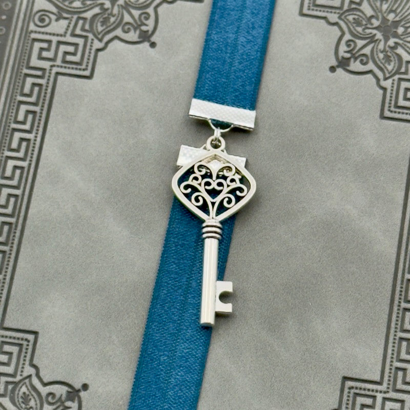 A silver key charm on a elastic Bookband