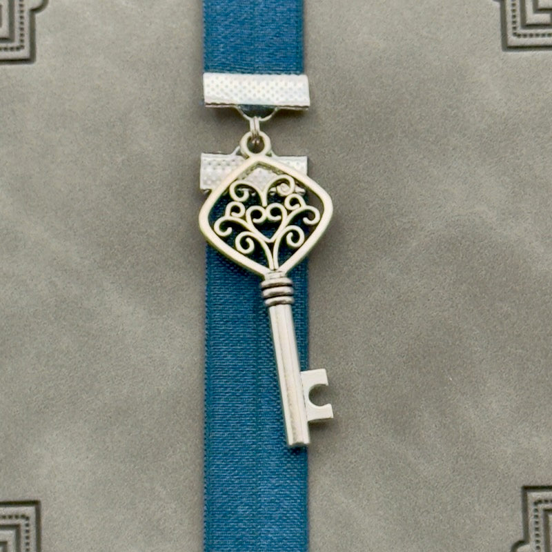 A silver key charm on a elastic Bookband