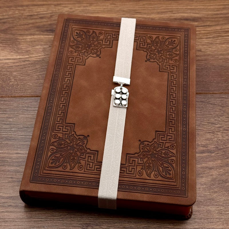 A silver muffin tin charm on an elastic Bookband