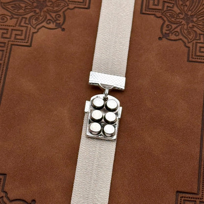 A silver muffin tin charm on an elastic Bookband