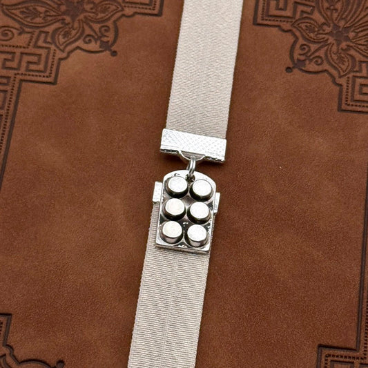 A silver muffin tin charm on an elastic Bookband