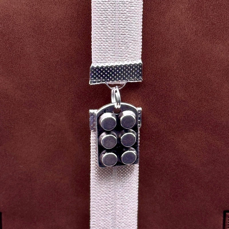 A silver muffin tin charm on an elastic Bookband