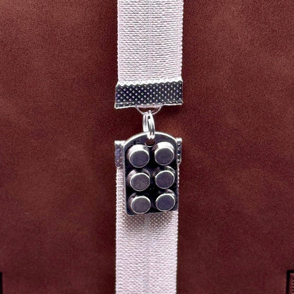 A silver muffin tin charm on an elastic Bookband