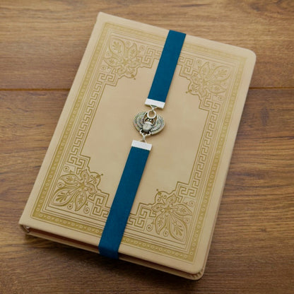 A silver scarab beetle charm on a elastic Bookband
