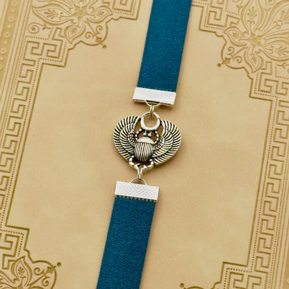 A silver scarab beetle charm on a elastic Bookband