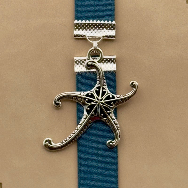 A silver starfish charm on a elastic Bookband