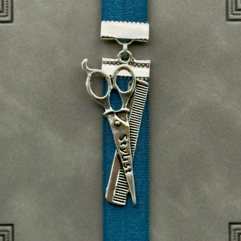 A silver hairstylist scissors and comb charm on a elastic Bookband