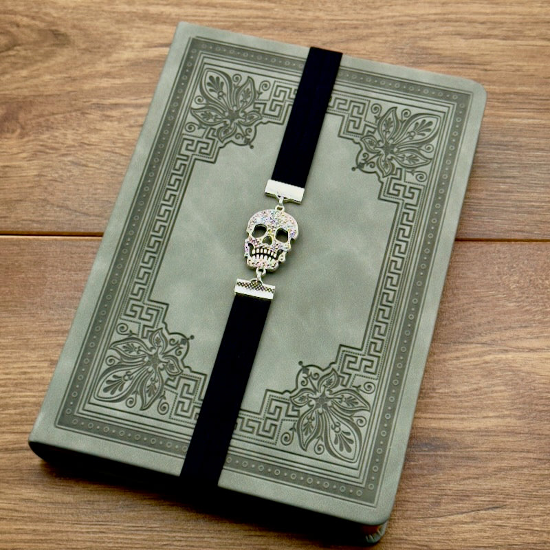 A silver cubic zirconia Sugar Skull charm on a elastic Bookband
