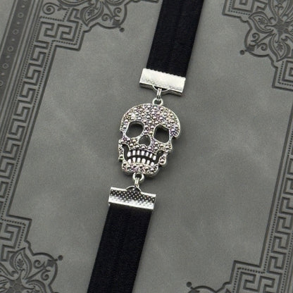 A silver cubic zirconia Sugar Skull charm on a elastic Bookband