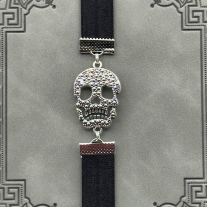 A silver cubic zirconia Sugar Skull charm on a elastic Bookband