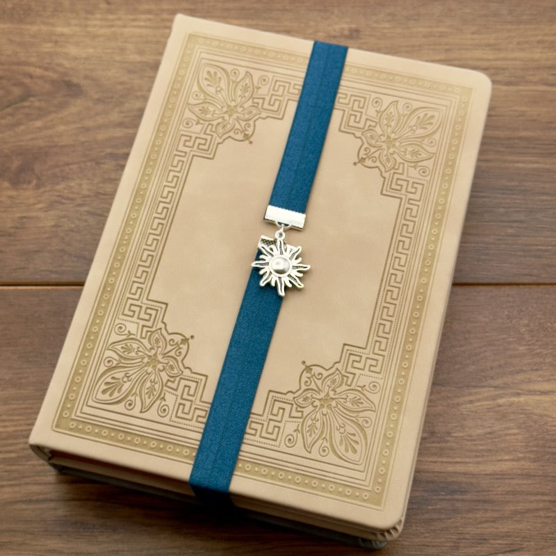 A silver sun charm on a elastic Bookband