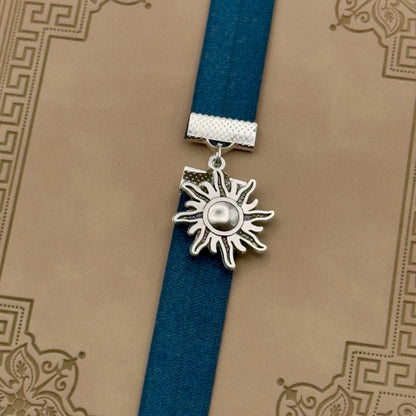 A silver sun charm on a elastic Bookband
