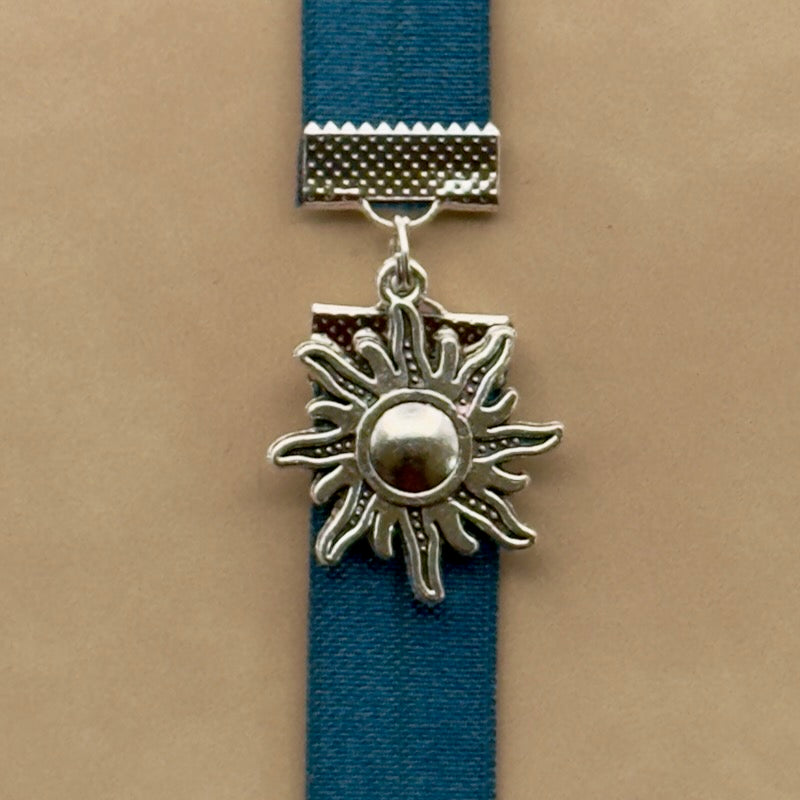 A silver sun charm on a elastic Bookband