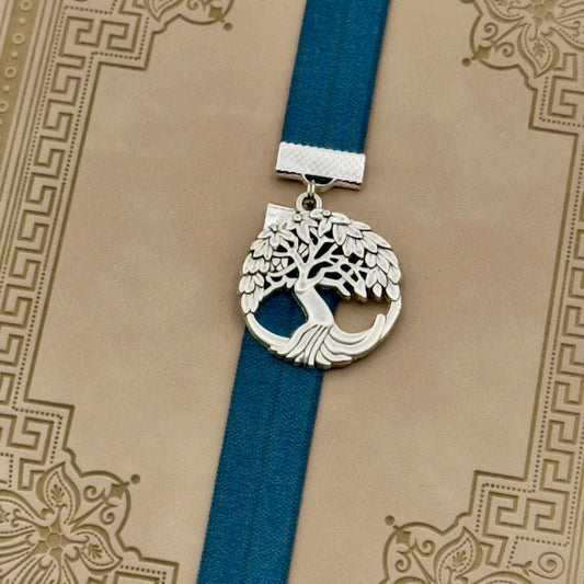 A silver tree of life charm on an elastic Bookband