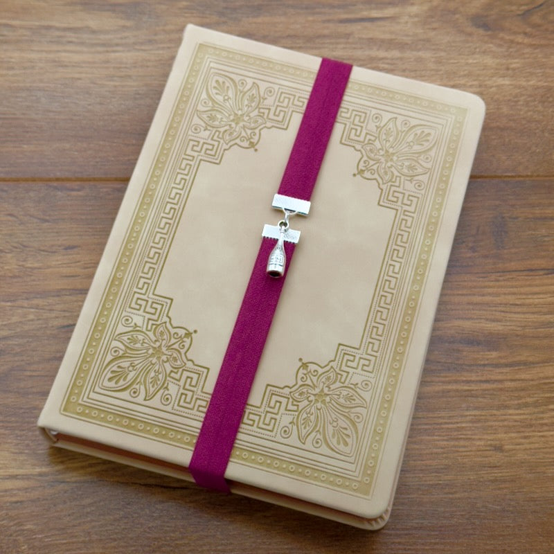 A silver wine bottle charm on an elastic Bookband