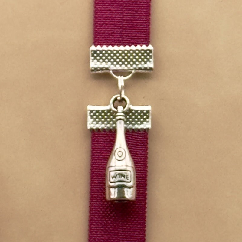 A silver wine bottle charm on an elastic Bookband