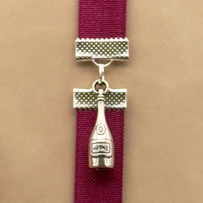 A silver wine bottle charm on an elastic Bookband