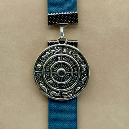 A silver zodiac charm on an elastic Bookband