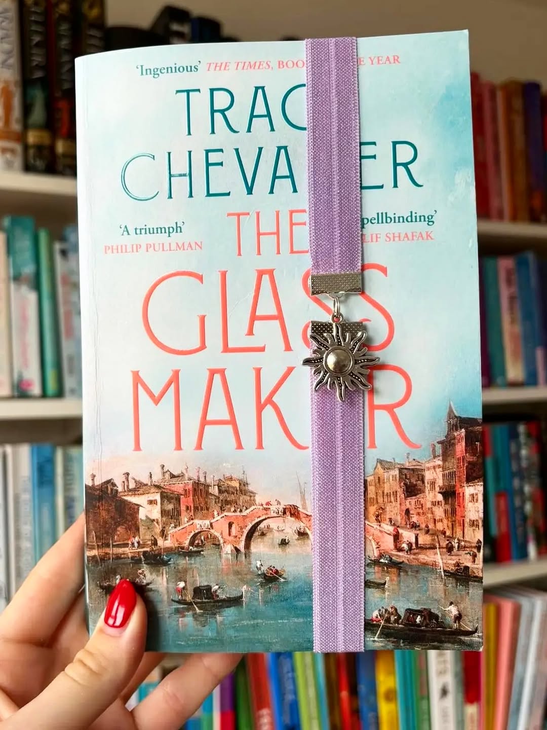 Book titled 'The Glass Maker' with a bookmark with a sun themed elastic bookband bookmark.