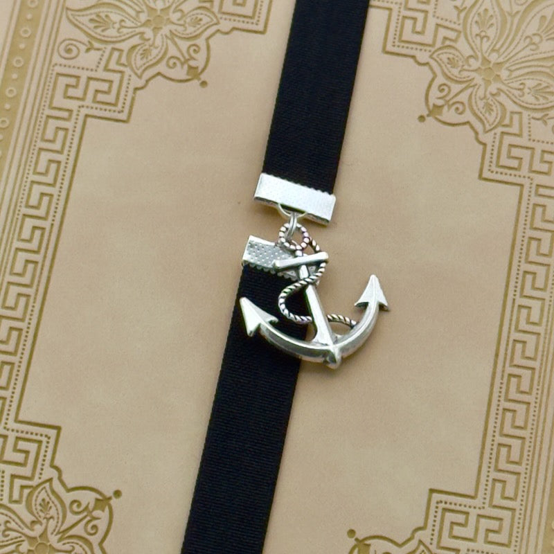 A silver anchor charm on a bookband elastic bookmark