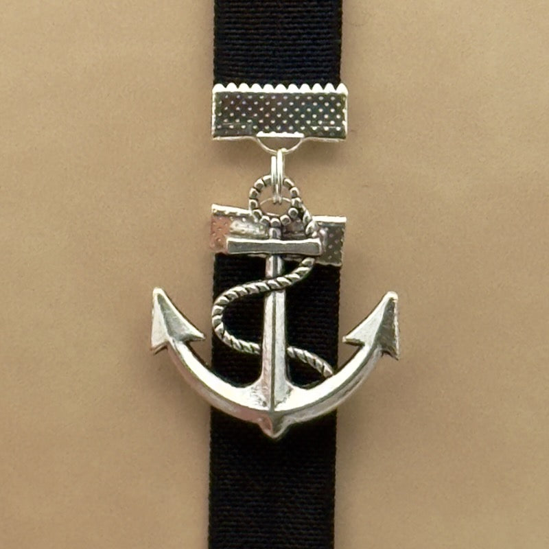 A silver anchor charm on a bookband elastic bookmark