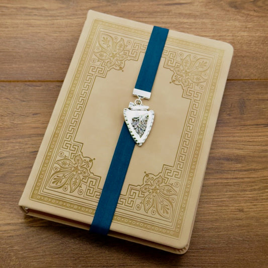 A silver arrowhead, with a howling wolf in the centre, charm on a elastic Bookband