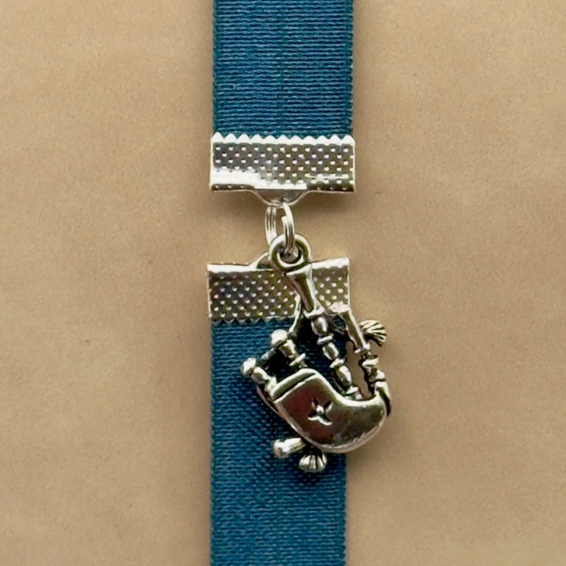 A silver bagpipes charm on a elastic Bookband