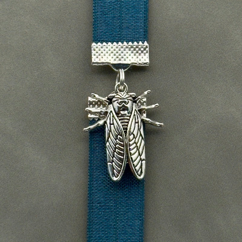 A silver cicada charm on a elastic Bookband
