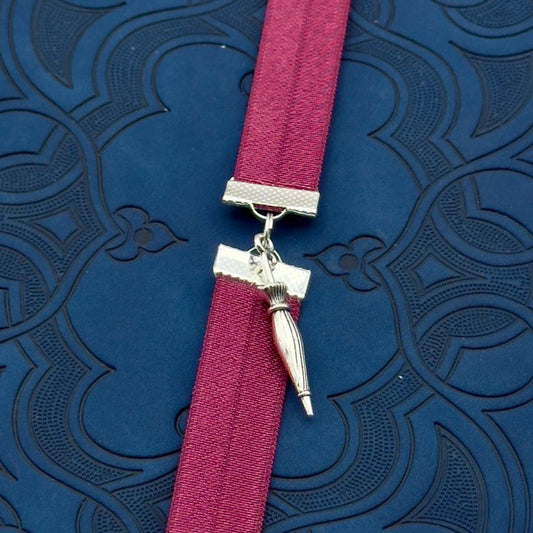 A silver umbrella charm on an elastic Bookband
