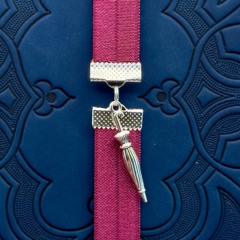 A silver umbrella charm on an elastic Bookband