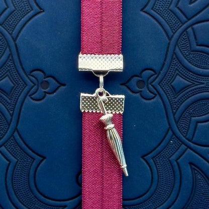 A silver umbrella charm on an elastic Bookband